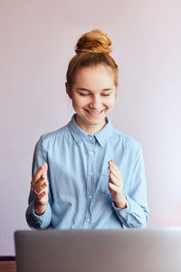 Portrait of smiling young woman using phone