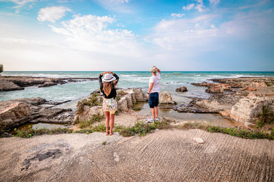 Rear view of women standing on beach