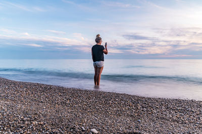 Man standing on beach against sky