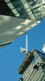 Low angle view of modern office building against blue sky