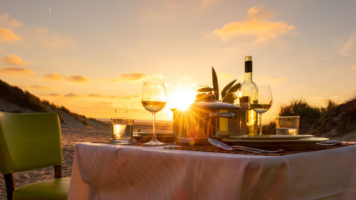 Restaurant and table against sky during sunset