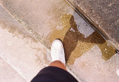 Low section of man standing on wet floor