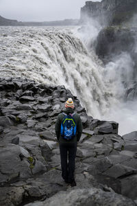 Rear view of man standing on rock