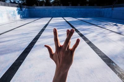 Reflection of person hand on swimming pool