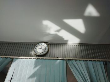 Low angle view of clock on wall