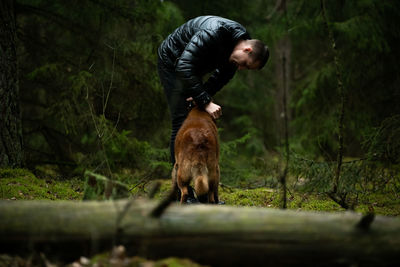 Full length of man with dog in forest
