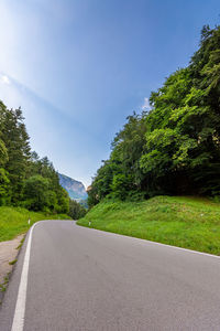 Road amidst trees against clear sky