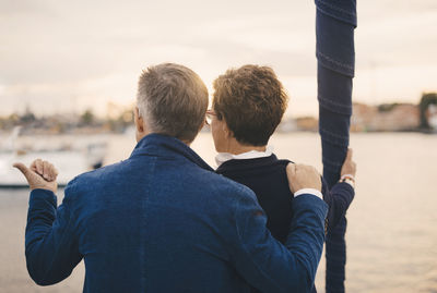 Rear view of senior couple talking while traveling in yacht