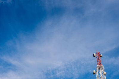 Low angle view of crane and building against blue sky