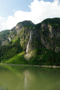 Scenic view of lake by mountain against sky