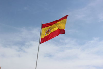 Low angle view of flag flags against sky