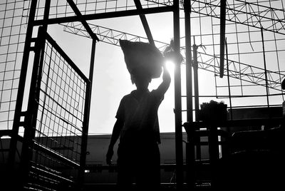 Low angle view of worker carrying sack at construction site