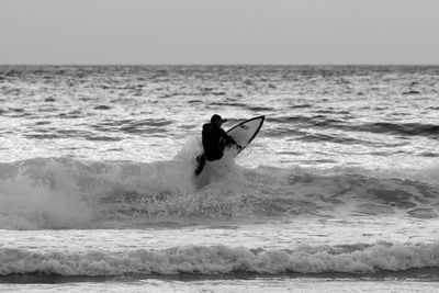 Man surfing in sea against clear sky