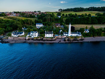 Lighthouse by houses on shore of river tay