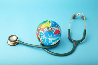 Close-up of globe with stethoscope over blue background