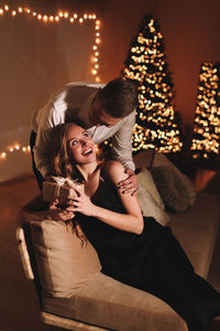 A romantic couple in love celebrates christmas holidays and new year in a cozy house at night