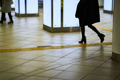 Low section of woman walking at subway station