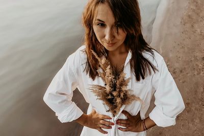 Portrait of beautiful woman standing against white water