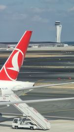 Airplane on airport runway against sky