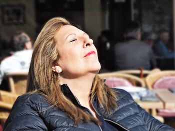 Close-up of mature woman sitting at outdoor cafe