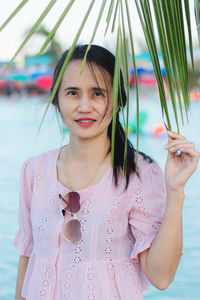 Portrait of woman standing against water