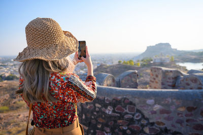 Rear view of woman photographing