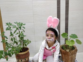 Portrait of cute girl in potted plant