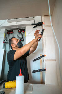 Man using clamps to hold workpiece gluing. diy project at home.