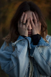 Portrait of a woman hiding face covered with hand