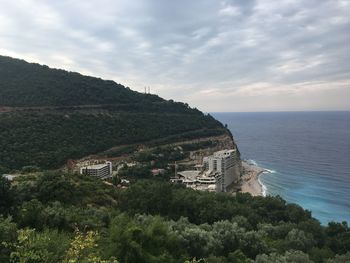 Scenic view of sea by buildings against sky