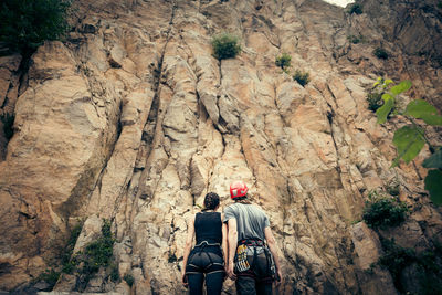 Rear view of people walking on rock