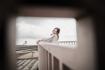 Woman standing by railing