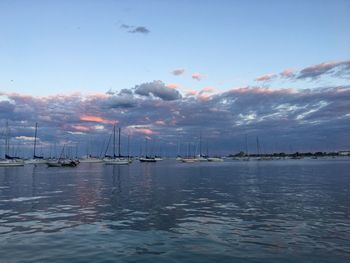 Sailboats in sea against sky during sunset