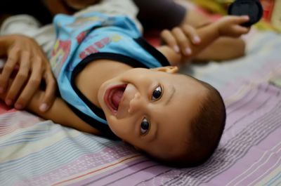 Portrait of cute baby lying on bed at home