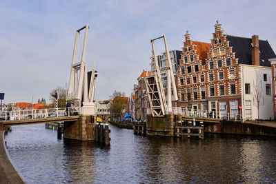 Gravestenen drawbridge raised over spaarne river with gable canal houses. haarlem, the netherlands