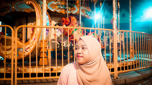 Portrait of woman in amusement park at night