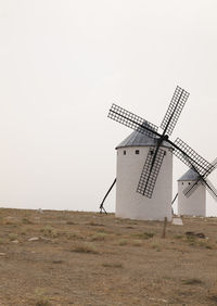 Spanish traditional white windmill on field against sky