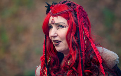 Close-up of mature woman with dyed hair and make-up looking away