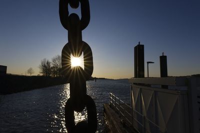 Man standing by sea against sky during sunset