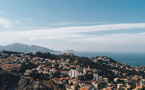 High angle view of townscape by sea against sky