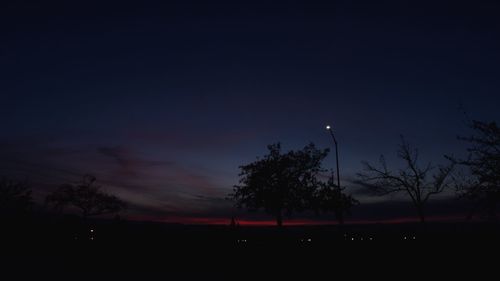 Low angle view of silhouette trees against sky at night