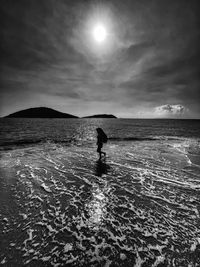 Silhouette person in sea against sky