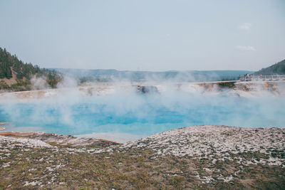 Epic scenic view of colorful steaming pool of geysers in yellowstone national park.