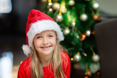 Portrait of cheerful girl wearing santa hat