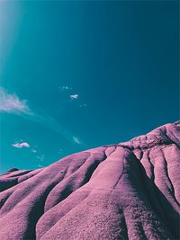 Low angle view of rocks against blue sky