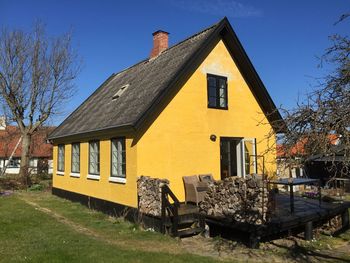 Exterior of yellow house against clear blue sky