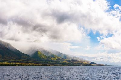 Scenic view of lake by mountains against sky