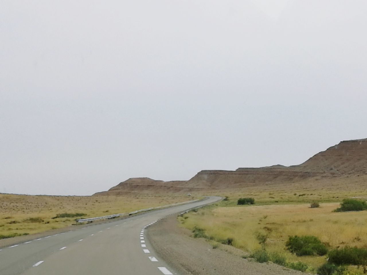 ROAD BY MOUNTAINS AGAINST SKY