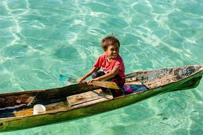 High angle view of smiling boy floating on water