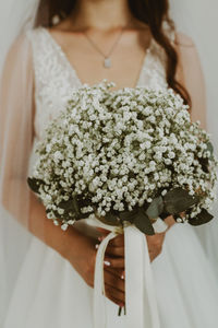 Portrait of a young unrecognizable caucasian bride with a bouquet of boutonnieres.